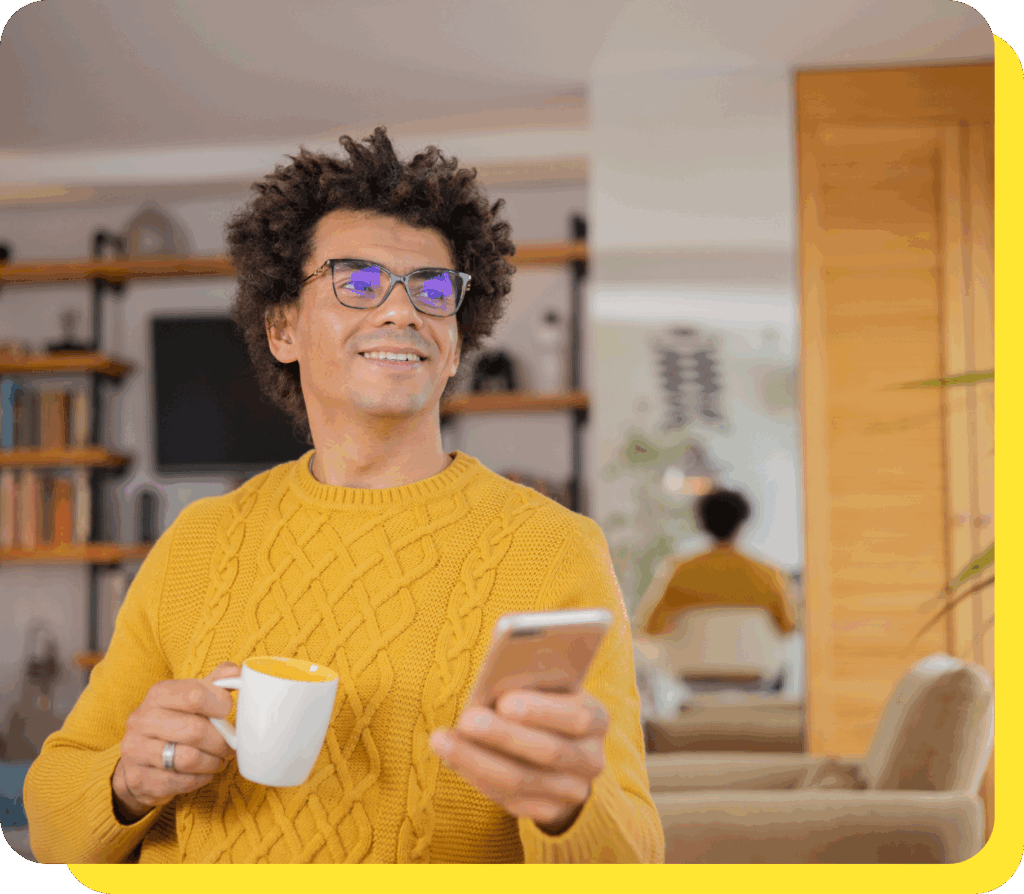Man smiling while using his phone, enjoying the convenience of a regular savings account.
