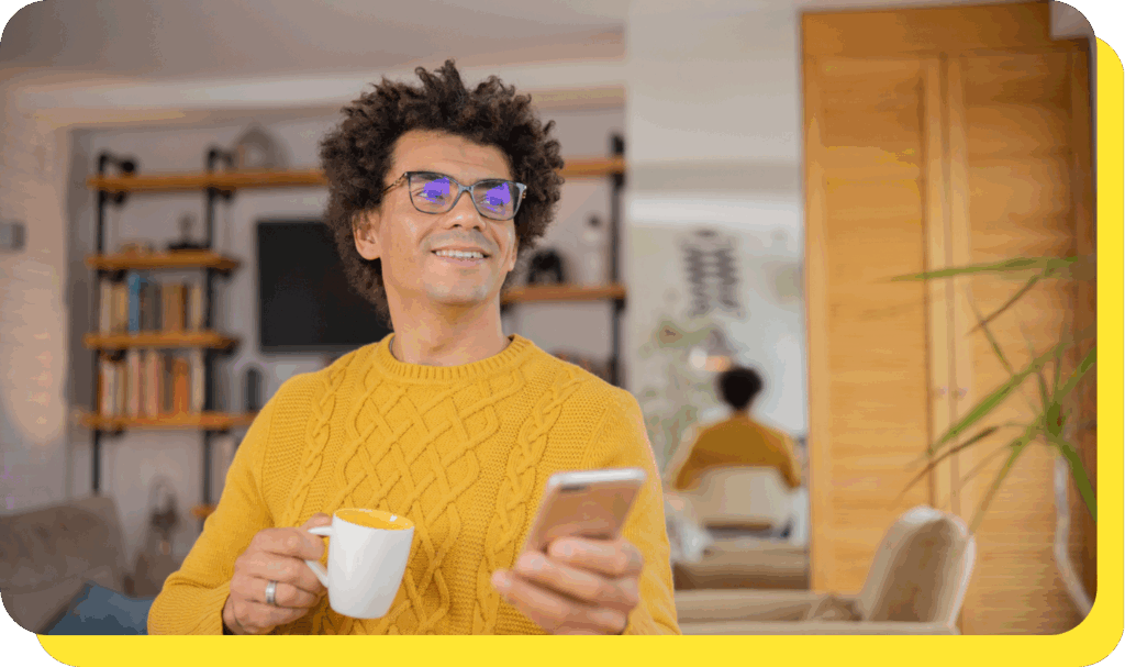 Man smiling while using his phone, enjoying the convenience of a regular savings account.