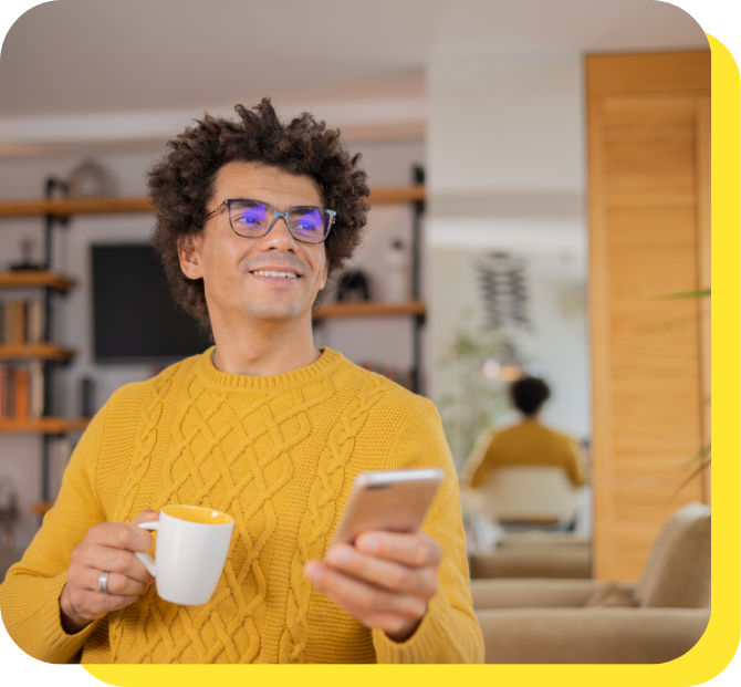 Man smiling while using his phone, enjoying the convenience of a regular savings account.