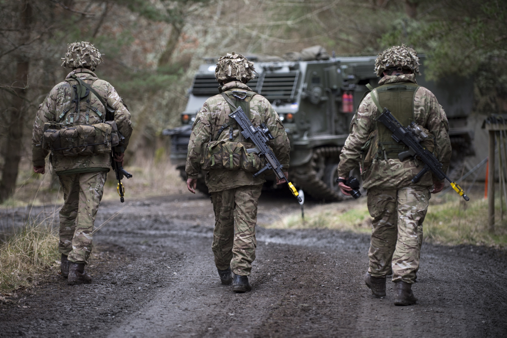 Three soldiers in uniform viewed from behind.