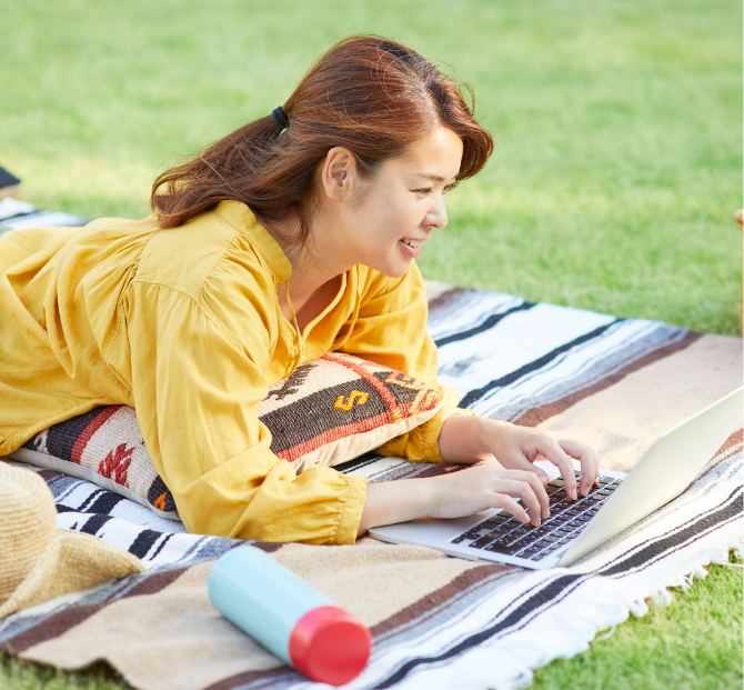 Woman smiling with laptop while using a goal savings calculator