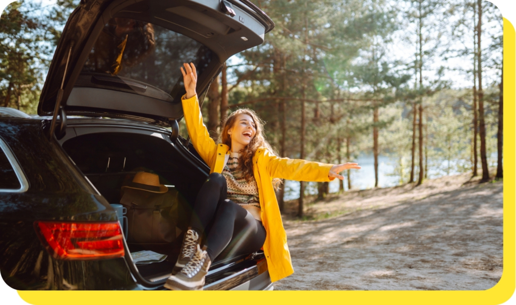 A happy woman sitting in her new car, showcasing the benefits of credit union car loans for affordable and flexible financing.