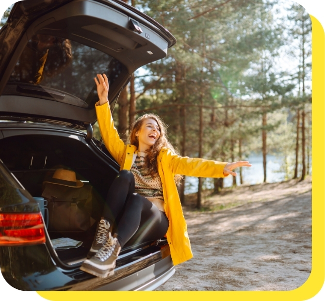 A happy woman sitting in her new car, showcasing the benefits of credit union car loans for affordable and flexible financing.