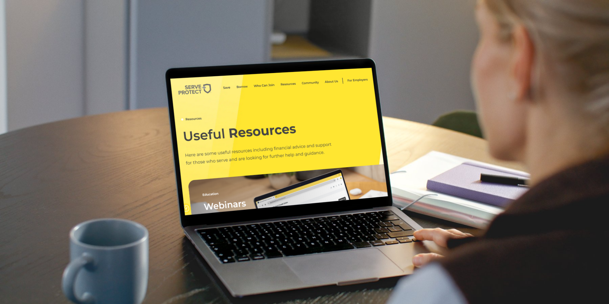 Person using laptop, displaying the 'Useful Resources' page from Serve and Protect Credit Union's website