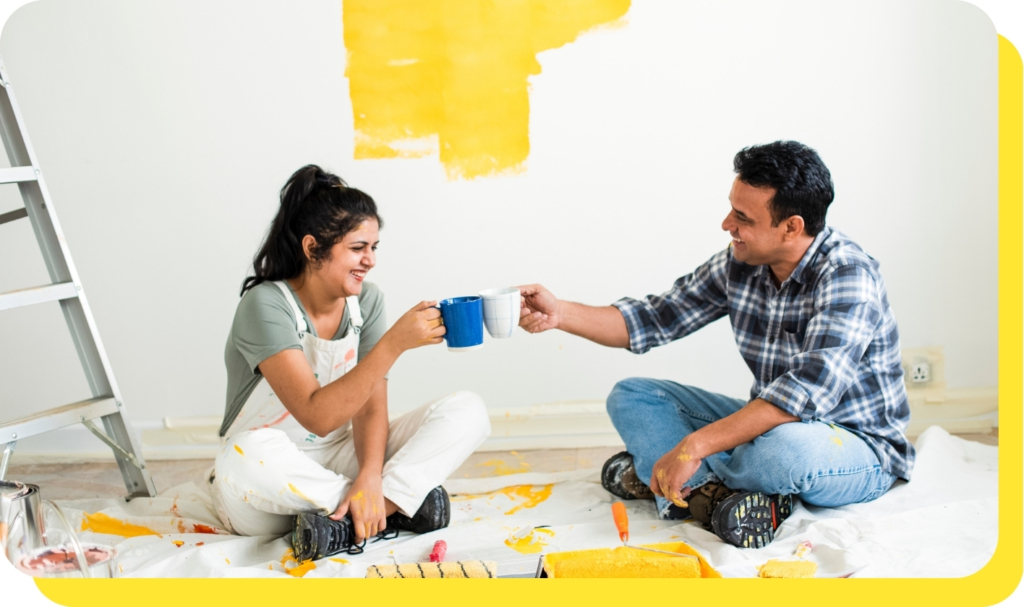 A happy couple cheersing mugs together, celebrating their successful home renovation funded by a Serve and Protect home improvement loan.