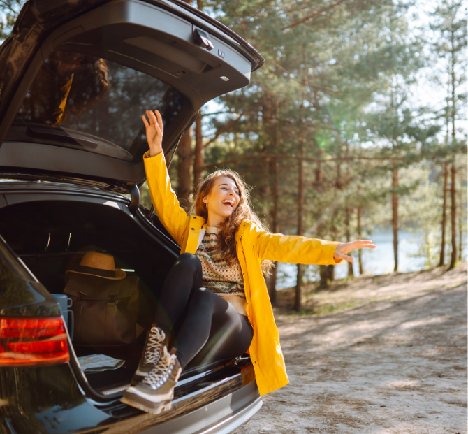 A happy woman sitting in her new car, showcasing the benefits of credit union car loans for affordable and flexible financing.