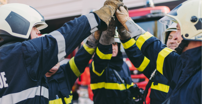 Firefighters high-fiving to show positive wellbeing within the emergency services