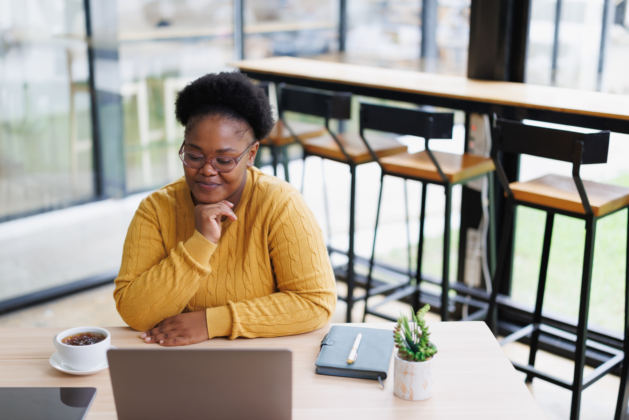 Woman smiling at her laptop while seated, promoting Workplace Loans.