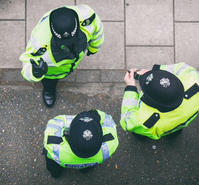 Police officers discussing using an overtime calculator to work out extra pay from additional hours