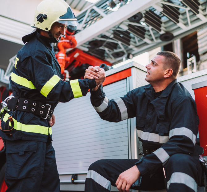 Firefighters talking after a shift while reviewing extra earnings with an overtime calculator