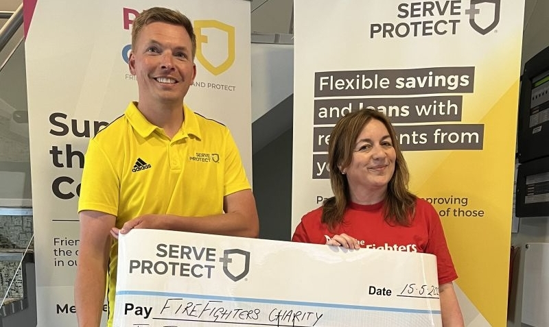 Rob Lovesey of Serve and Protect Credit Union provides cheque to Debbie Rushbrooke of the Fire Fighters Charity